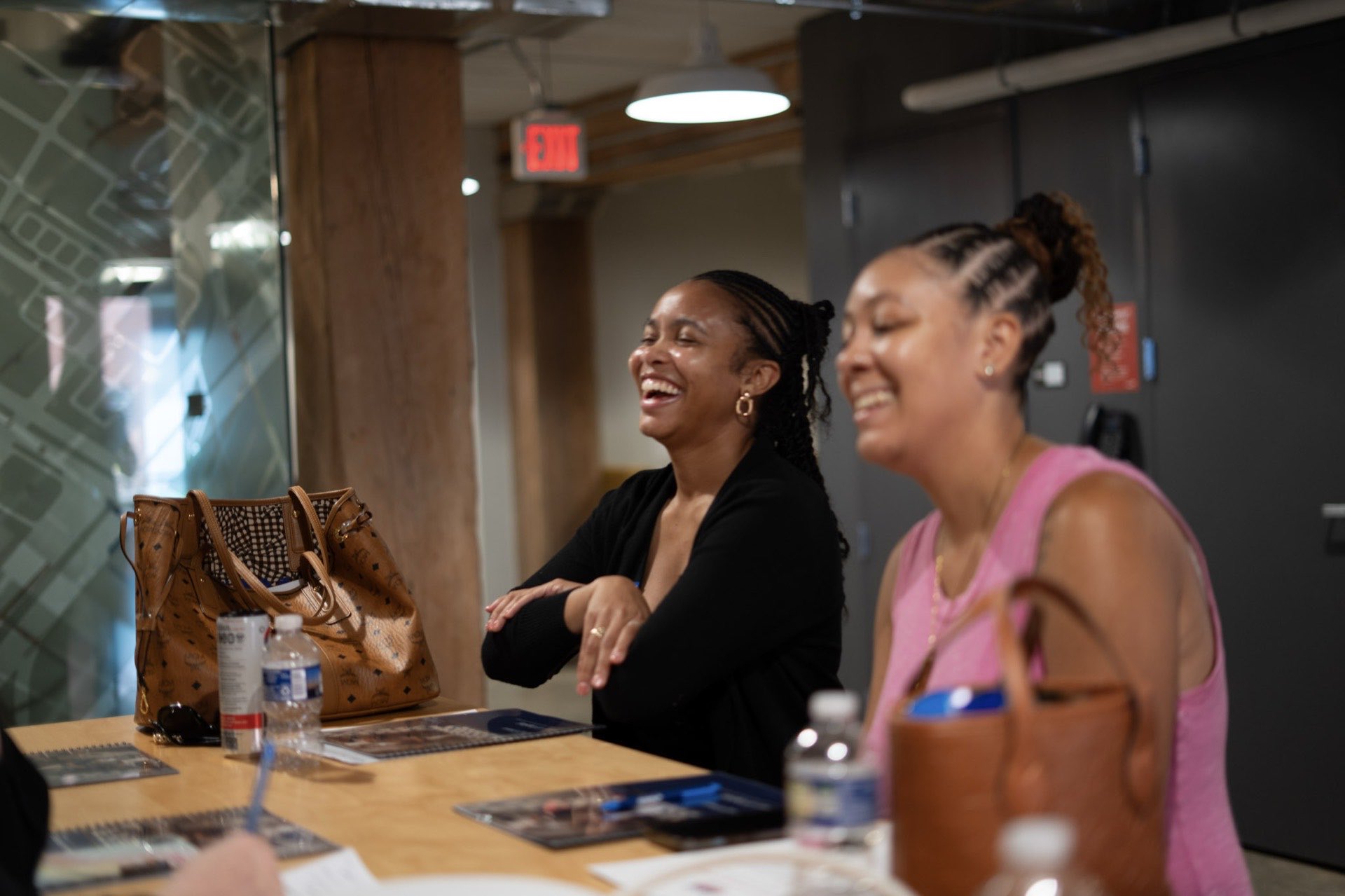 Two entrepreneurs cracking up at a table in a Richmond coworking space