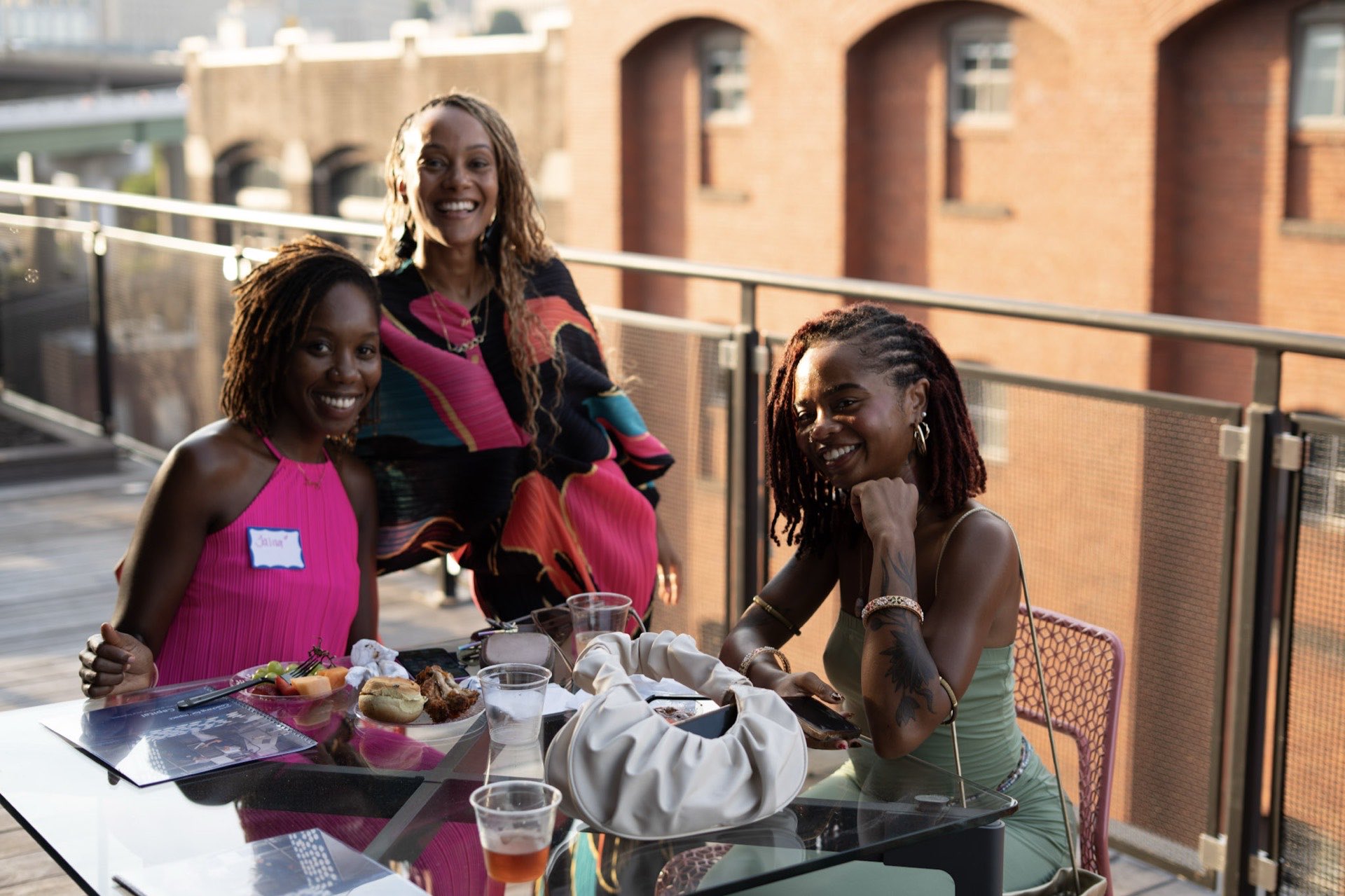 Founders laughing together at a rooftop table with the Richmond skyline behind them